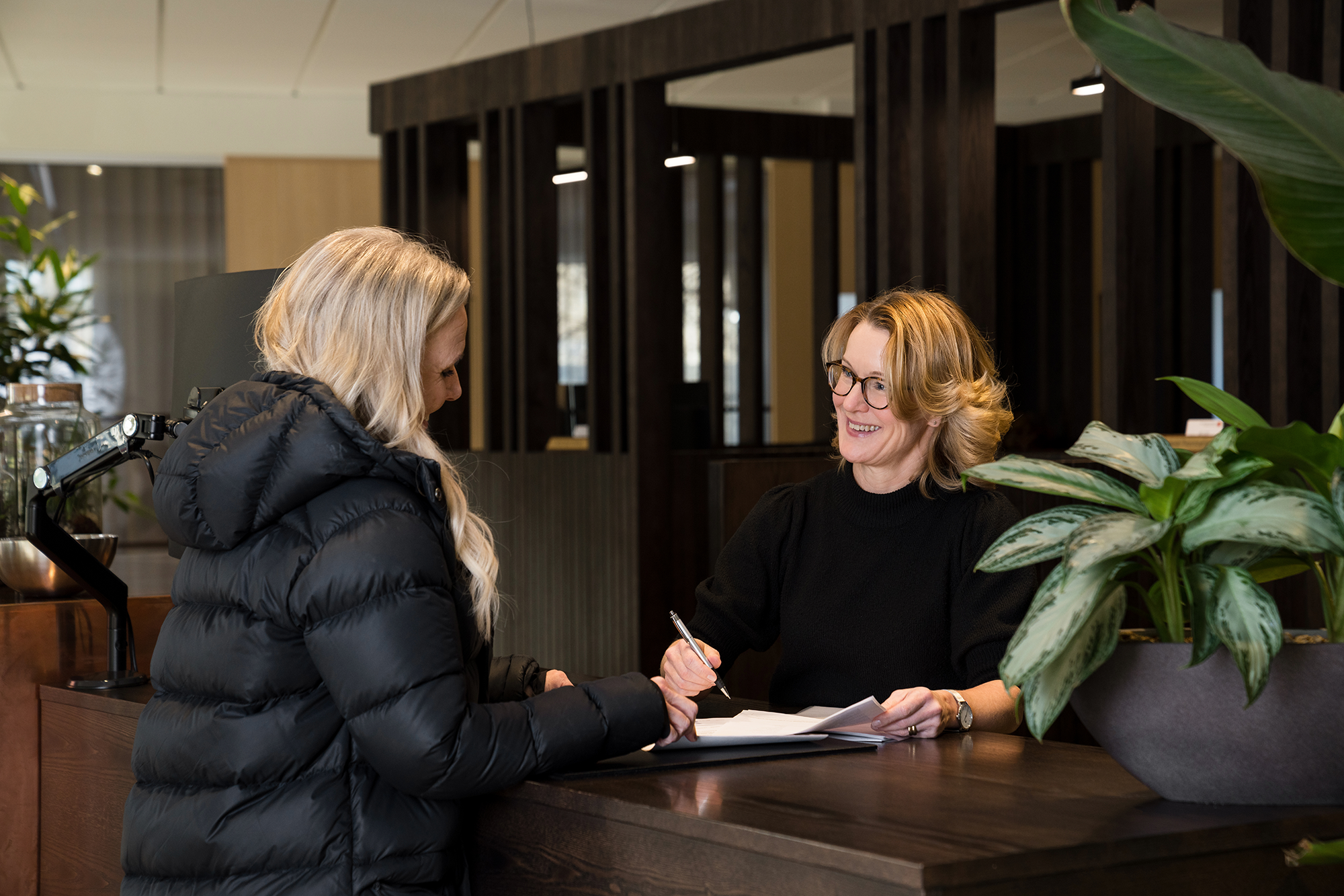 Servicerådgivare Ingela pratar med privatrådgivare Helena i kassan