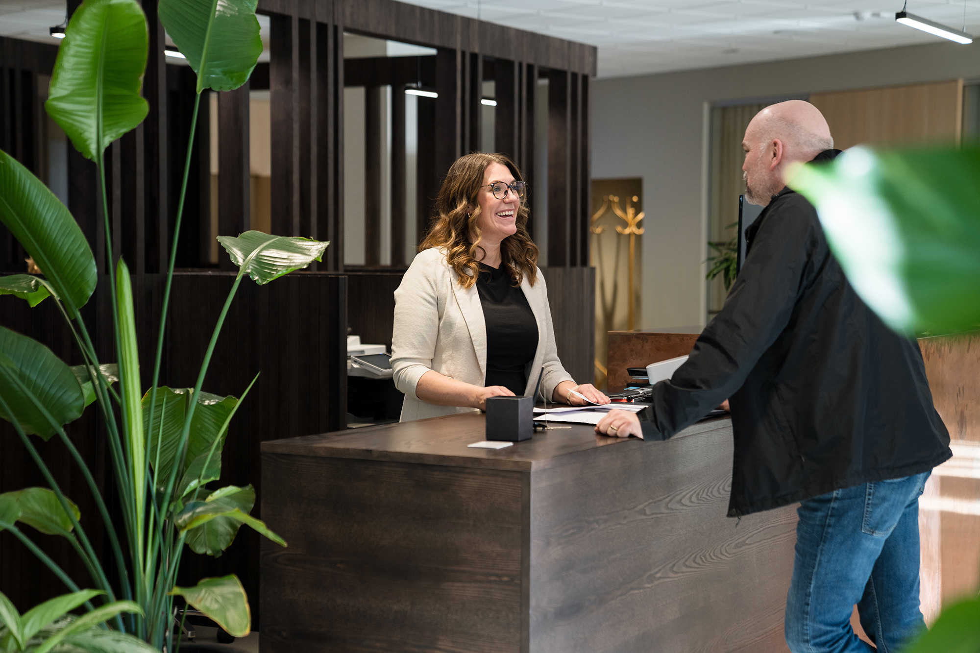 Servicerådgivare Lisa står i kassan och pratar med en kund